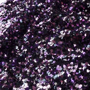 Detailed macro shot of shimmering purple and black gradient sequins on dress fabric