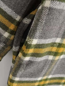 Close-up of thick plaid flannel fabric in grey and mustard yellow for winter coats