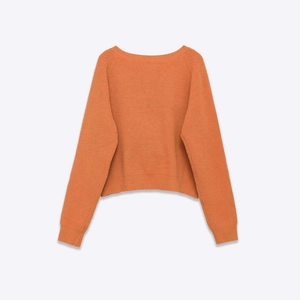 Terracotta knit sweater with dropped shoulders and ribbed cuffs on a white background