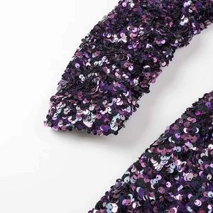 Close-up of purple and black gradient sequins on waist-cinching evening dress fabric