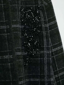 Détail du tissu à carreaux gris avec broderies florales en perles et sequins brillants