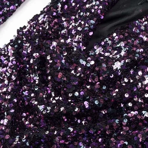Detail of shimmering purple and black sequins on high-quality party dress fabric