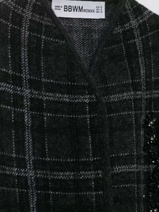 Détail du tissu en maille à carreaux gris avec ornements élégants de paillettes et perles