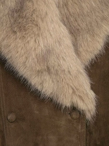 Gros plan sur la veste d'hiver en suédine avec col en fourrure et boutons recouverts