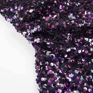 Detailed close-up of shimmering purple and black gradient sequins on an elegant dress