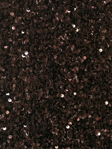 Détail macro de tissu à paillettes marron foncé avec un lustre métallique sur jupe longue
