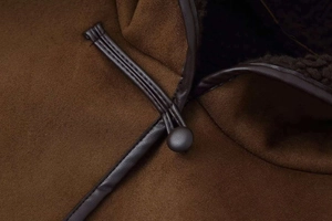 Close-up of deep brown suede jacket featuring traditional toggle buttons and warm lining
