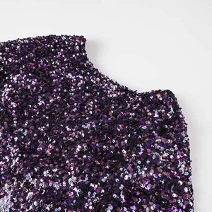 Detail of high-density purple sequin gradient on the neckline and shoulder of a dress