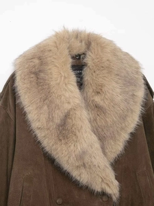 Dettaglio ravvicinato di giacca in pelle scamosciata marrone con collo in eco-pelliccia