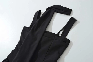 Detail of the chic halter neckline and asymmetric straps on this black pleated waist dress
