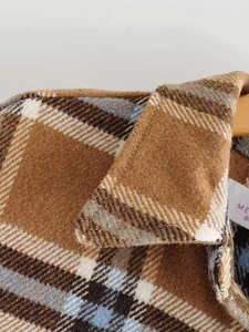 Detailed view of brown plaid woolen jacket collar with soft textured fiber fabric