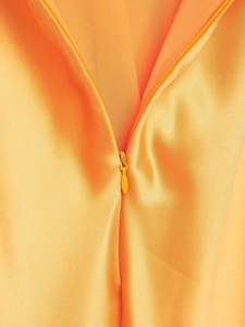 Vue macro détaillée d'une robe en satin orange avec une fermeture éclair invisible discrète