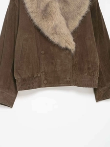Détail d'une veste en daim avec un large col amovible en fausse fourrure brune