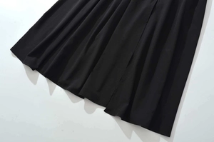 Close-up of black pleated fabric texture with elegant drape on long summer dress