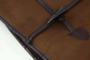 Detailed macro view of deep brown suede jacket with classic toggle horn button closure