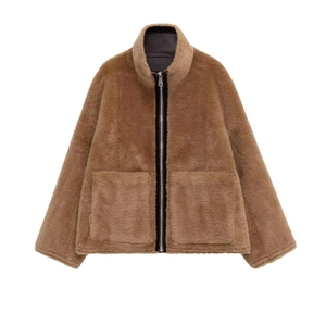 Détail d'une veste en peluche marron foncé avec col montant et grandes poches plaquées
