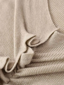 Gros plan détaillé montrant la texture en maille fine et les fronces sur ce gilet kaki