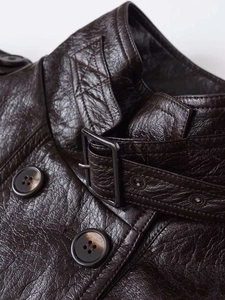 Detail of vintage textured dark brown faux leather jacket with metal buckle collar