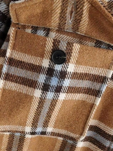 Close-up of retro plaid wool shirt fabric with a black button and chest pocket detail