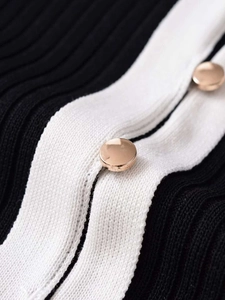 Détail de la maille contrastée avec boutons dorés et texture côtelée verticale chic