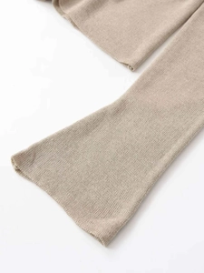 Gros plan détaillé sur la maille beige montrant la texture côtelée et le poignet évasé