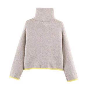 Detail of oatmeal knit sweater with vibrant yellow contrast trim on cuffs and hemline