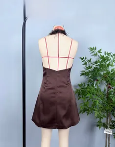 Détail d'une robe dos nu en satin marron avec des plumes assorties sur l'encolure