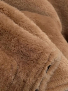 Gros plan sur la texture douce du polaire camel sur une veste d'hiver à col montant