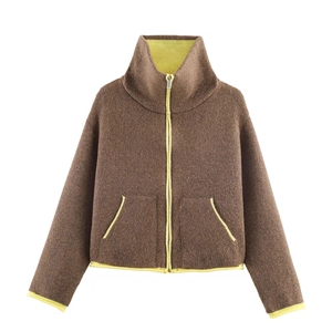 Close-up of contrast neon yellow piping and zipper detail on brown knit jacket