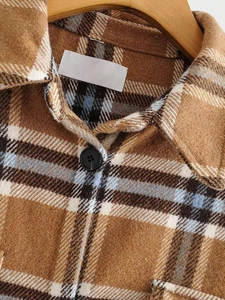 Close-up of the thick flannel plaid texture and matte black button on the winter shacket
