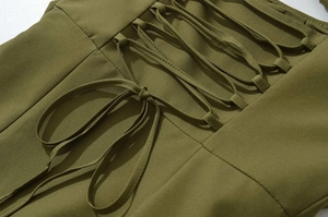 Detailed close-up of the olive green dress featuring lace-up crisscross back details