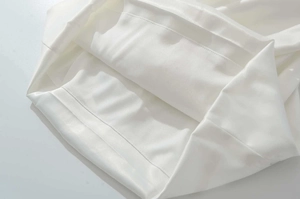 Close-up of white square neck dress showing silky fabric texture and neat stitching details