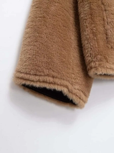 Détail de la manchette d'une veste en peluche camel montrant la texture épaisse polaire
