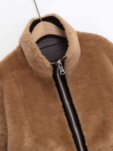Gros plan sur une veste en fausse fourrure marron avec col montant et fermeture éclair
