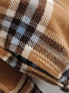 Close-up detail of heavy brown and blue plaid wool fabric texture for casual winter shirts