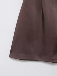 Vue détaillée de la robe dos nu marron foncé montrant les coutures et le tissu plissé de qualité