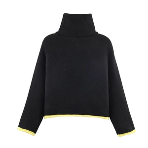 Detail of high collar black knit sweater with contrast yellow ribbed cuffs and hem