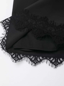 Detailaufnahme des eleganten schwarzen Wimpernspitzensaums an einem glatten Minirock