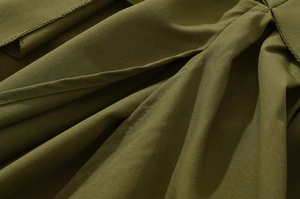 Close-up of army green pleated fabric showing high-quality stitching and texture
