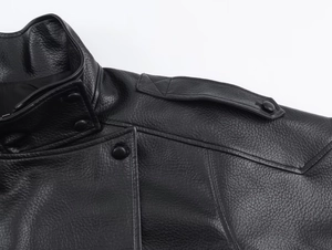 Detail of black leather jacket showing shoulder straps and snap button collar stitching
