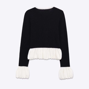 Pull en maille côtelée noire avec finitions volantées blanches au col et poignets