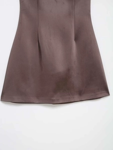 Gros plan détaillé de l'ourlet en satin marron avec texture soyeuse brillante