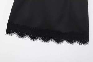 Detaillierte Ansicht des eleganten schwarzen Spitzenbesatzes am Saum eines Satinrocks