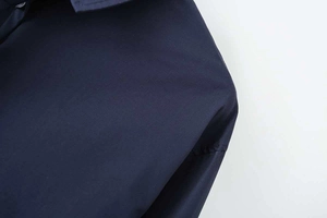 Detailed close-up showing the side pocket stitching and smooth navy cotton poplin fabric