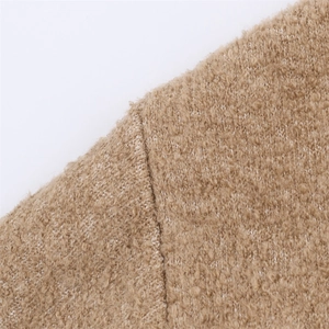 Close-up detail of warm camel teddy fleece fabric showing soft texture and stitching