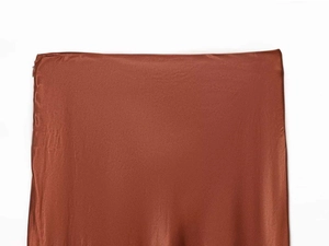 Detail of reddish-brown satin midi skirt featuring a side invisible zipper and silky texture