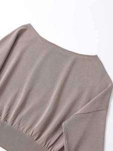 Detailed close-up of dark brown off-shoulder knit top with fine texture and ribbed hem