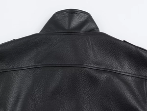 Close-up of litchi texture pattern and stitching on a vintage black leather jacket