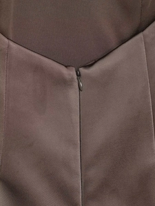 Détail d'une fermeture éclair invisible sur la robe dos nu marron à plumes chic