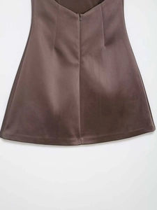 Détail d'une robe en satin marron avec finition brillante et fermeture éclair invisible